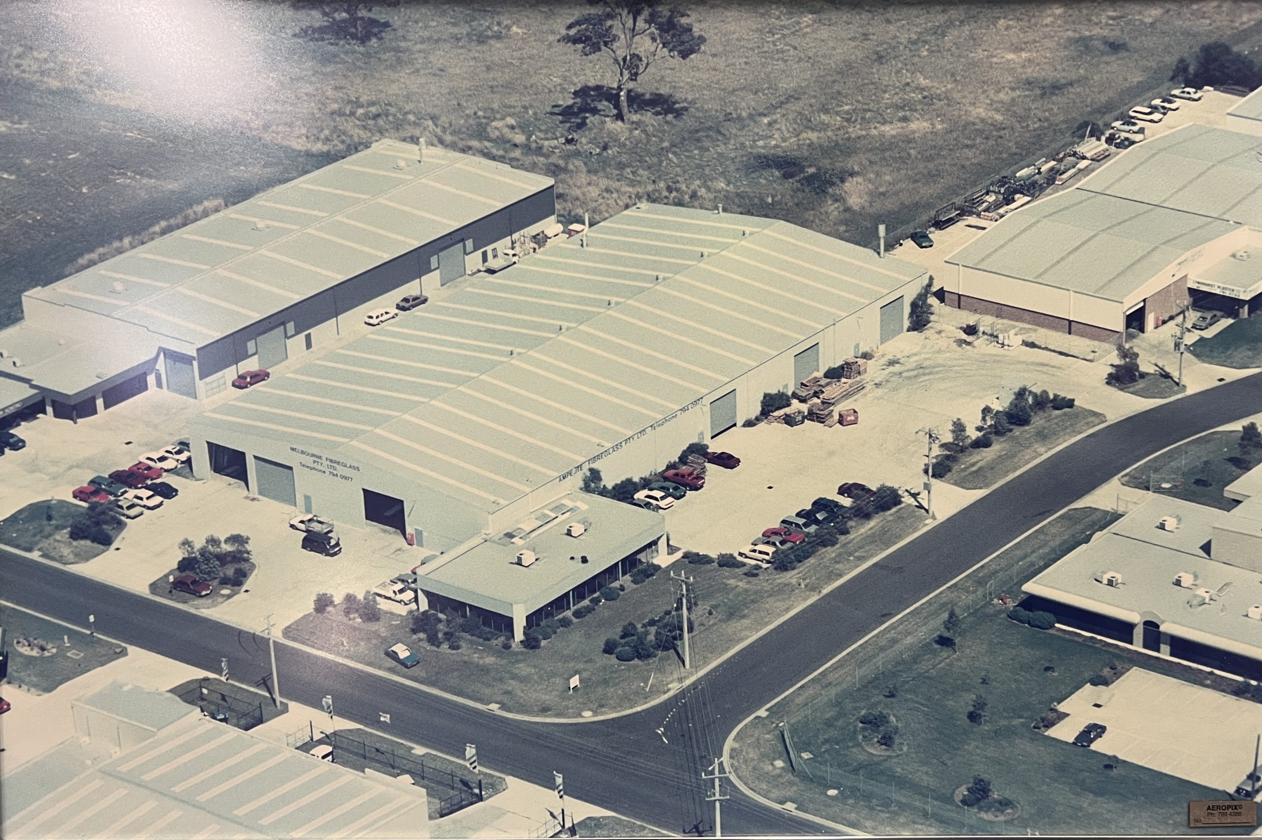 Historic black and white photo of the original Ampelite factory building and surrounding area